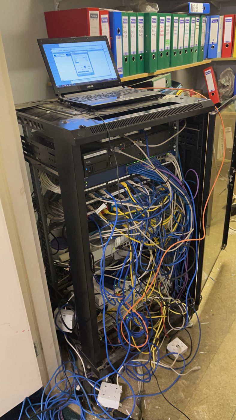 A small-office network cabinet with tangled cabling